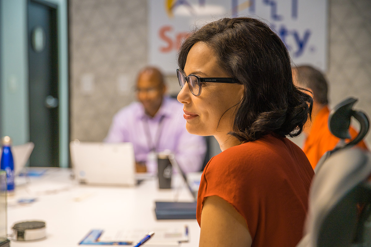 Woman sitting in a meeting room with coworkers