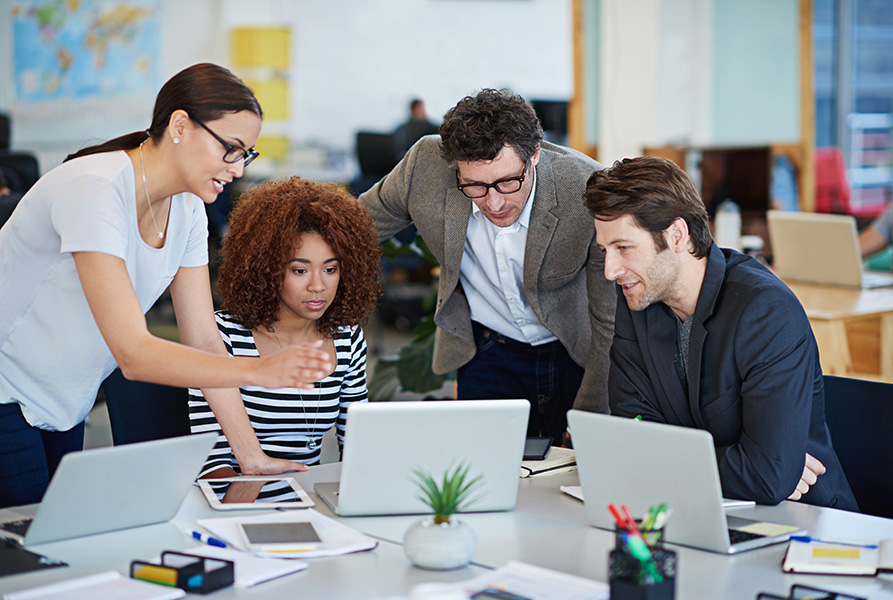 Business people working on laptops around a table