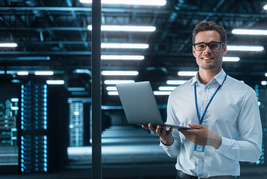Late at Night in Private Office Male Businessman Works on a Laptop Computer.