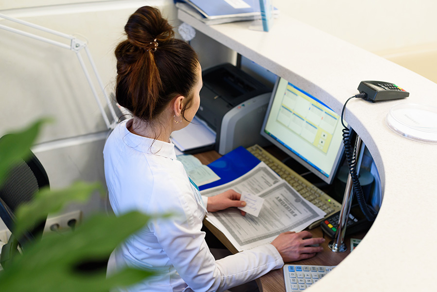 Female receptionist working the computer.