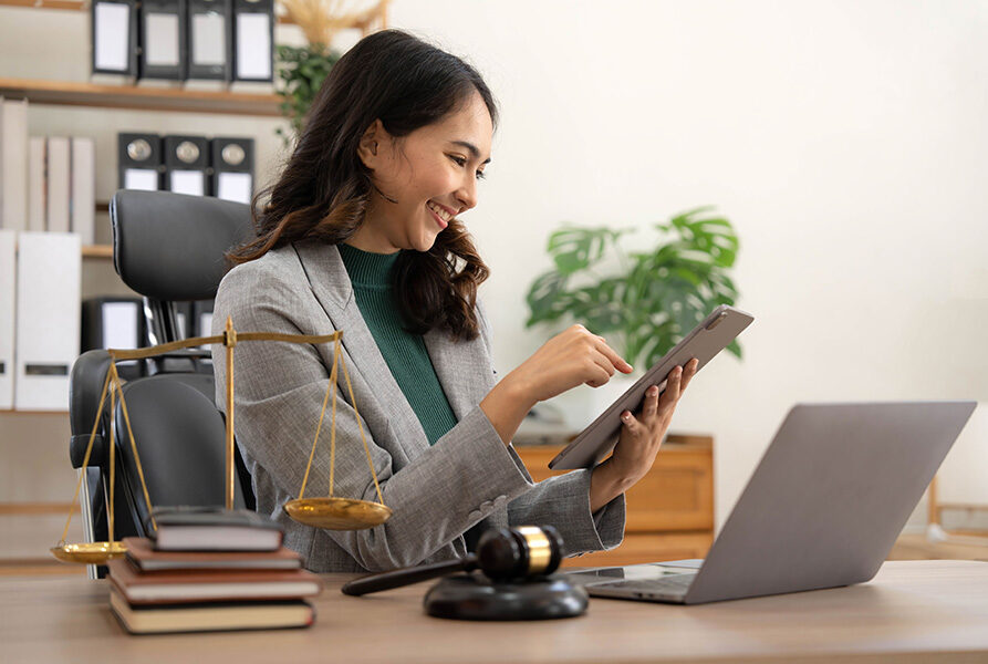 A judge in a courtroom the gavel, working with tablet and laptop